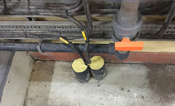 Sealing cable entries at a Thames Water project near Maple Cross, Berks. (Note: the two containers of yellow Densoseal are on the floor)
